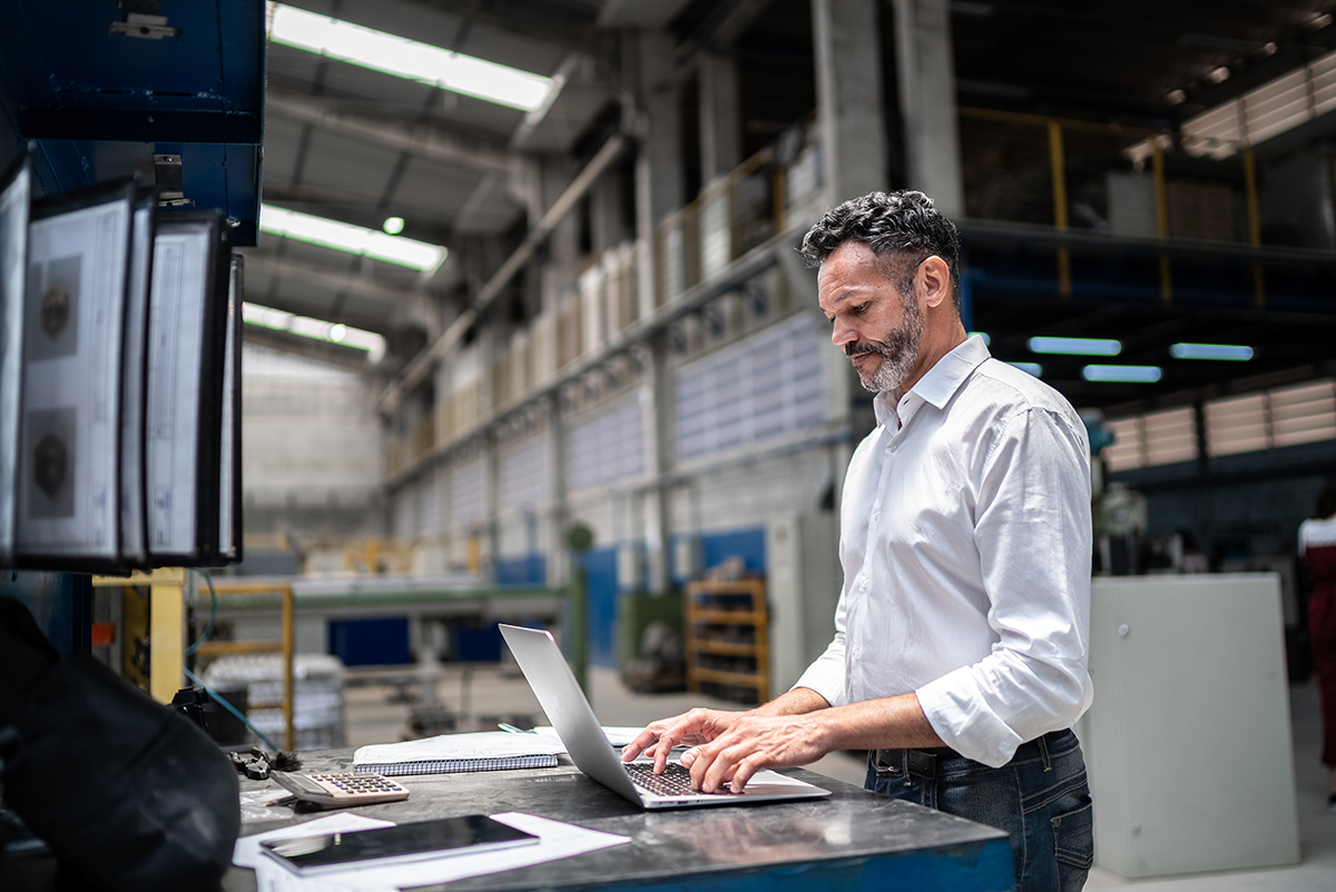 Man working at computer in a warehouse setting