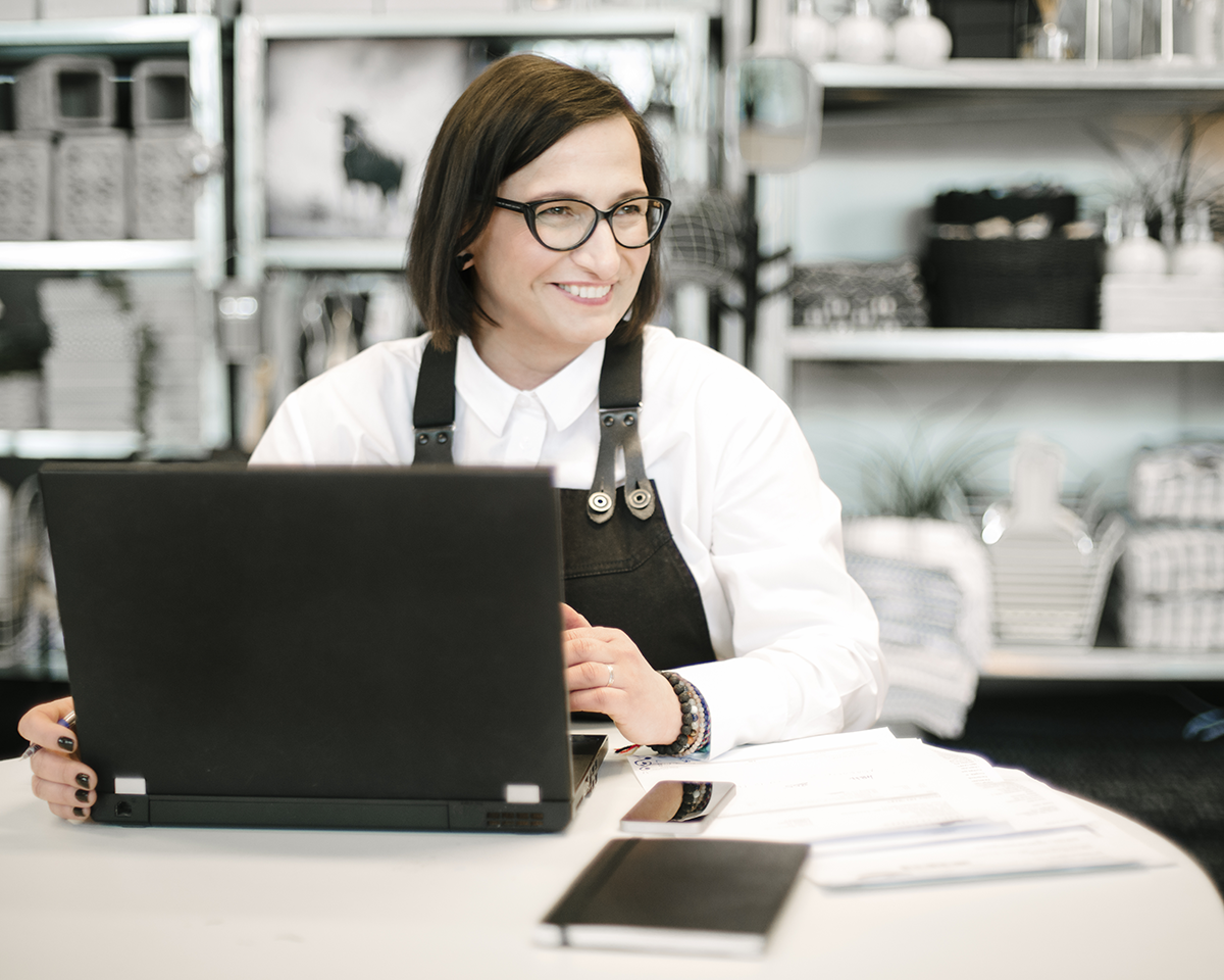 Woman at a computer smiling in a workshop